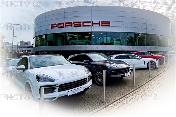 View of futuristic looking building with typical reduced architecture of showroom sales house of car brand car manufacturer Porsche with lettering Porsche at representation of car dealer Gottfried Schultz sales of sports cars brand Porsche