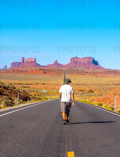 A young man in a white shirt on the road to Monument Valley. Utah