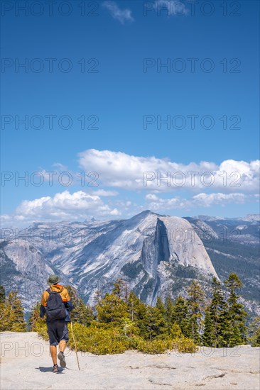 A young man walking along Sentinel Dome looking at Yosemite National Park. United States