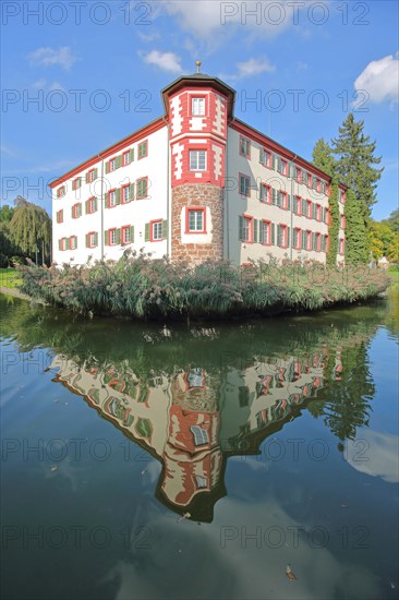 Moated castle built 16th century with reflection in the pond