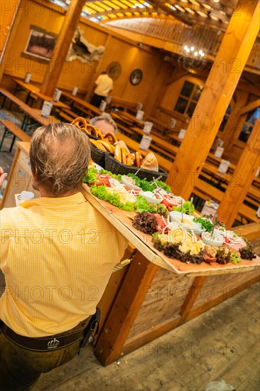 Waiter with full food plate in the festival tent