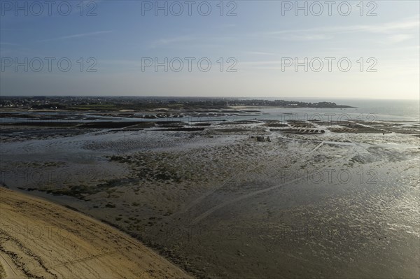 Aerial view of the sandy beach at Plouharnel Bay in Brittany. Oyster beds in the background. Morbihan