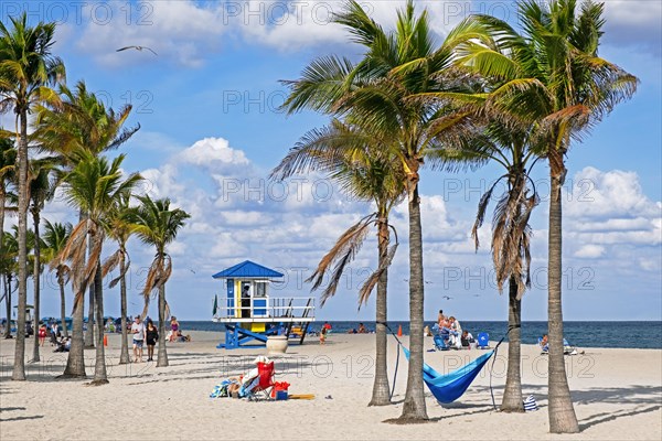 Tourists and lifeguard tower in winter on Surfside Beach along the Atlantic Ocean in Miami-Dade County