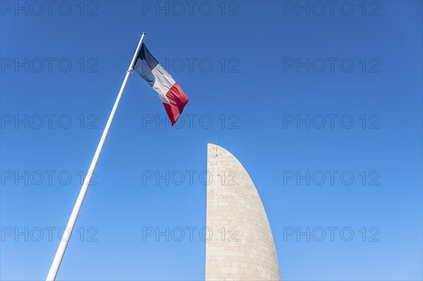 French national flag in front of the memorial Lighthouse of Remembrance at the former concentration camp Natzweiler-Struthof