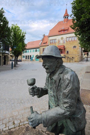 Stone mason fountain with sculpture and town hall