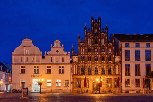 Architecture on the historic market square with town house and Gothic gabled house at the blue hour