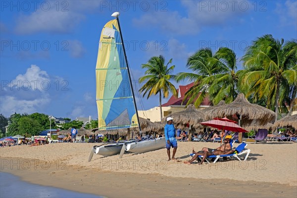 Tourists sunning on sandy beach of Rodney Bay