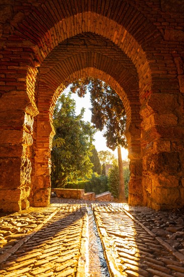 Sunset at the gate of the wall and the gardens of the Alcazaba in the city of Malaga