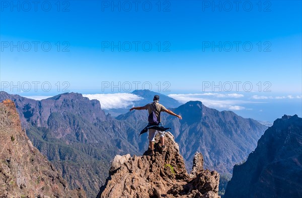 A young man after finishing the trek at the top of the volcano of Caldera de Taburiente near Roque de los Muchachos one summer afternoon