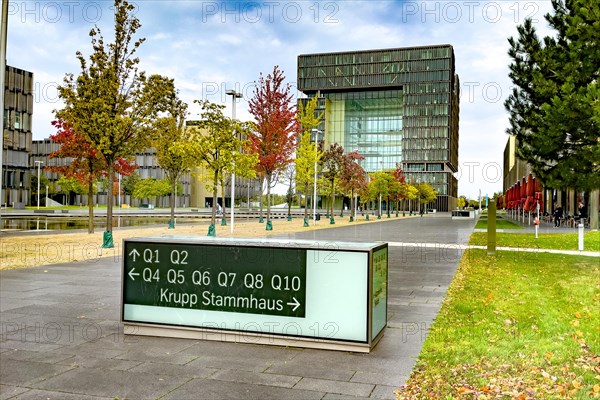 View of headquarters in the background in the form of cube of steel giant company of steel production manufacturer of steel thyssenkrupp Thyssen Krupp in the foreground signpost and reference to ancestral home of family Friedrich Krupp