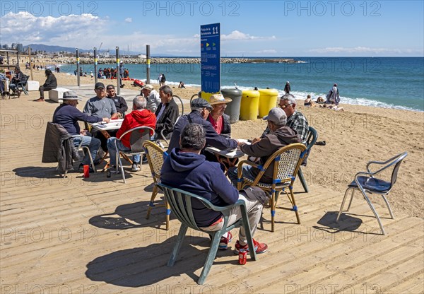 Group of men play dominoes at La Barceloneta beach