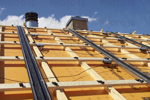 Substructure for an in-roof photovoltaic system on a roof. With foil for increased demands. Rails for rain drainage. Hooks for the solar modules