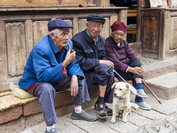 Old people sitting in front of the house