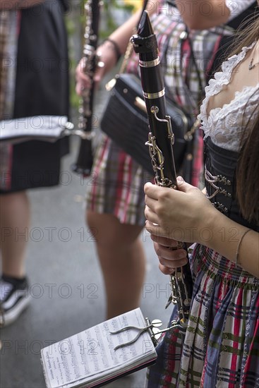 Musician holding her clarinet and sheet music ready to play