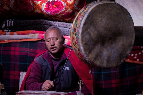 Buddhist monk performs puja in a nomadic tent