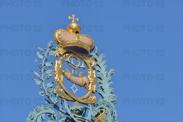 Golden crown with imperial orb and post horn with ornaments at the market fountain