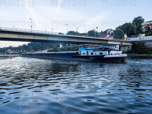 Cargo ship on the Danube under a bridge