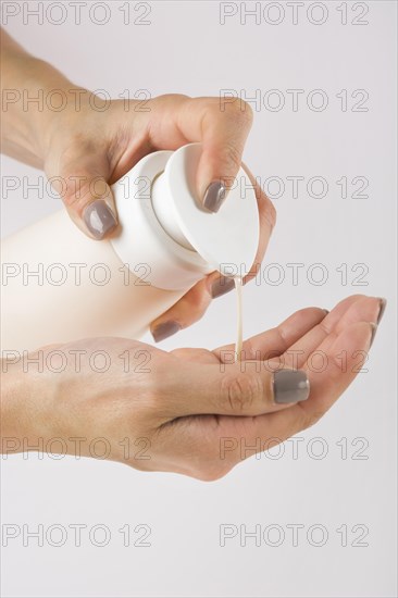 Close up female hands using hand sanitizer gel pump dispenser