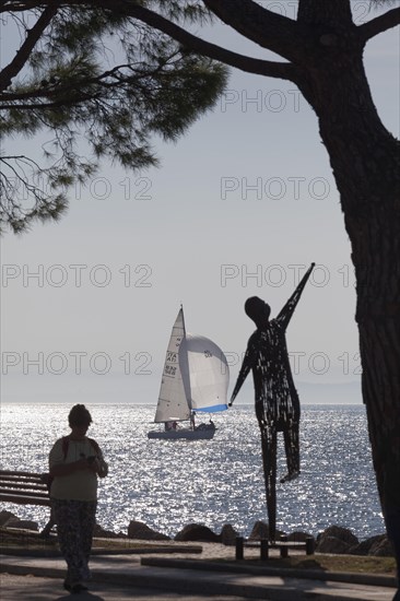 Lakeside promenade with metal sculpture by Ettore Peroni