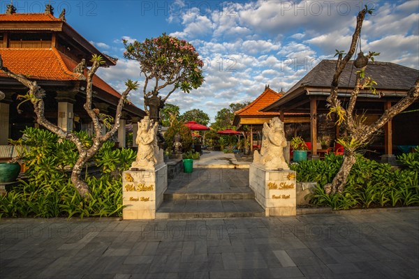 Park with tropical plants and traditional statues of the Hindu faith and for decoration. Tropical island life as a tourist on Bali