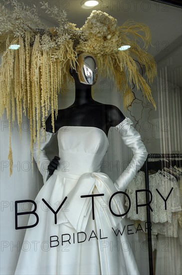 Shop window with black fashion doll in wedding dress
