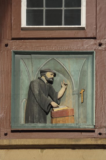 Relief with priest at lectern preaching from bible