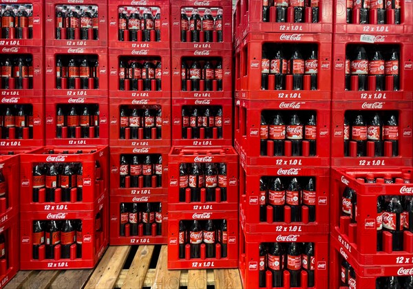 Display of in wholesale on pallet wooden pallet side by side one above the other stacked high red boxes con Coca Cola each with 12 twelve 1 litre bottle one litre bottle of plastic with sugary caffeinated soft drink with caffeine sugar
