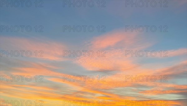 Orange reddish clouds Veil clouds Cirrostratus at the bluish evening sky at dusk