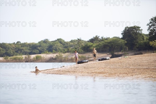 Brazilian children playing on the banks of the Rio Amazonas at low water level