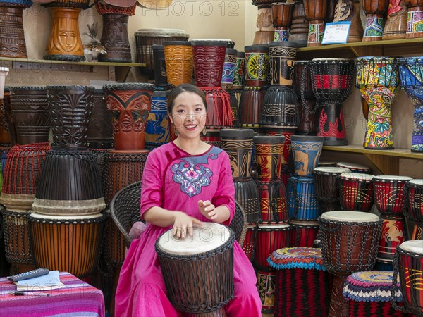 Young Chinese woman drumming and singing
