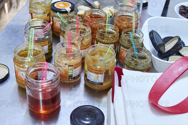 Opened tasting jars with different jellies and jams