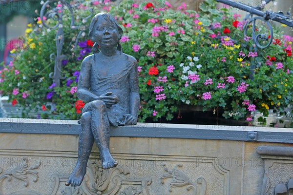 Sculpture Girl with flower decoration at the market fountain