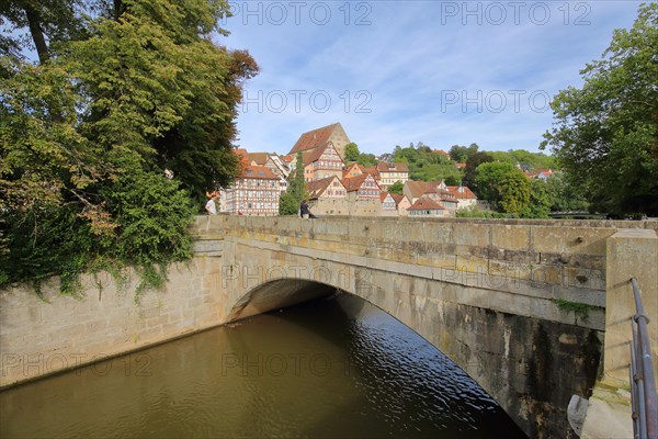 Stone arch bridge over the Kocher to the river island Unterwoehrd and townscape with new building