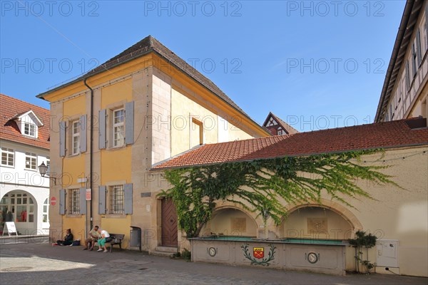 Building at the deer fountain with town coat of arms