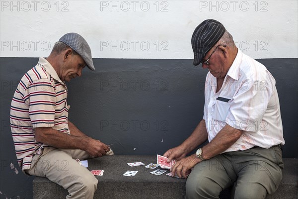 Men playing cards in the port of Camara de Lobos