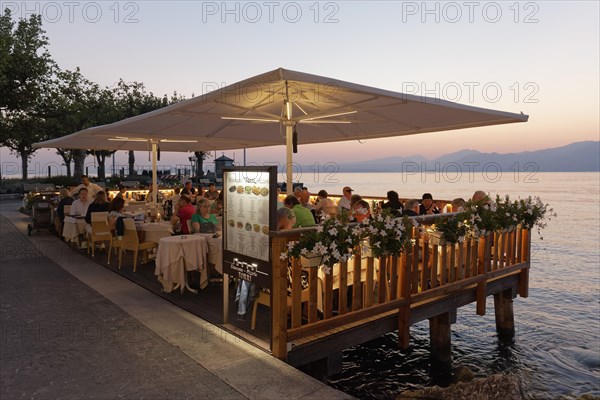 Restaurant terrace with guests on the lake shore