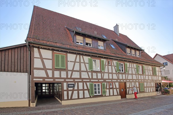 Brown half-timbered house with green shutters