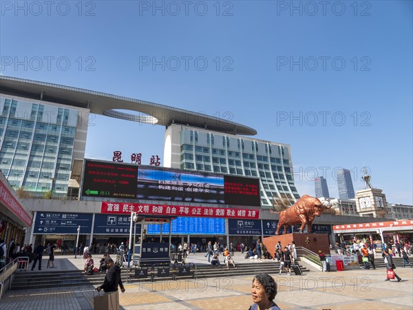 Station forecourt with passers-by and high-rise buildings