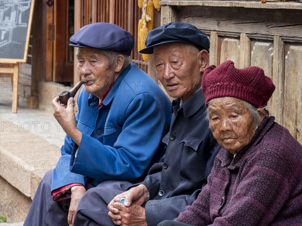 Old people sitting in front of the house