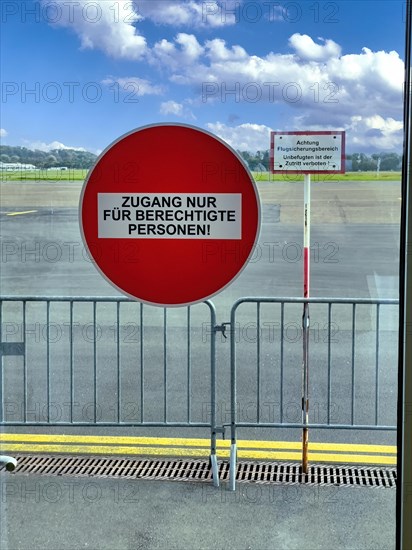 Round red prohibition sign on glass door Access only for authorised persons behind it sign with warning Notice Prohibition Attention Air Traffic Control Area Unauthorised persons are not allowed to enter