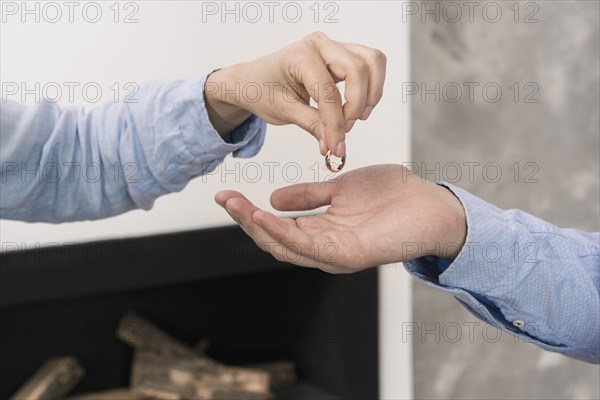 Close up couple taking wedding rings off