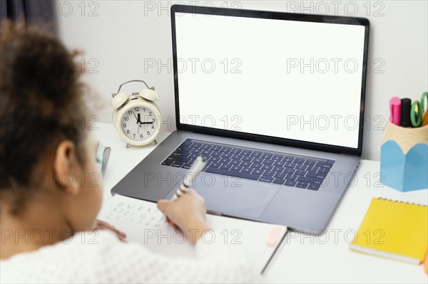 High angle little girl home during online school with laptop