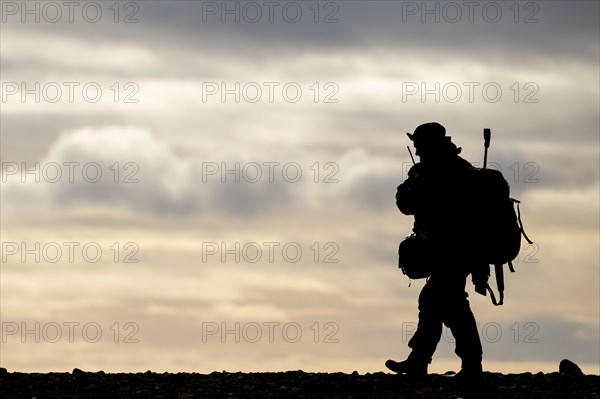 Silhouette of a walking man with radio