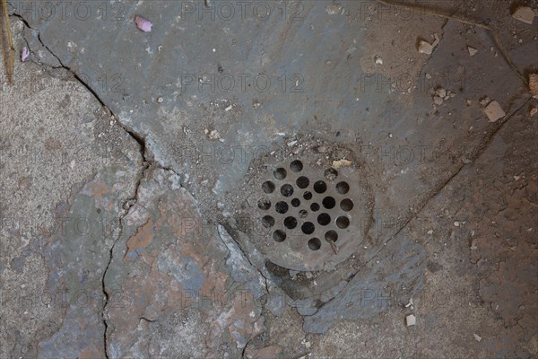 Metal drain in damaged concrete floor