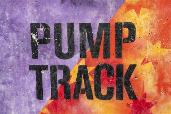 Black Pumptrack lettering against a colourful background