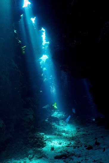 Diver swimming in cave