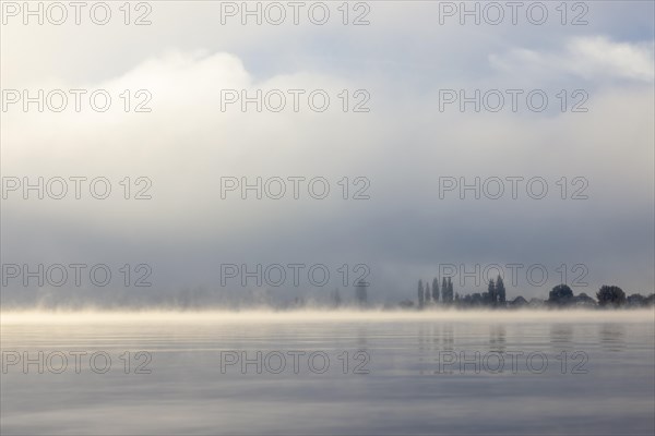 Fog over Lake Constance on an autumn morning with boats