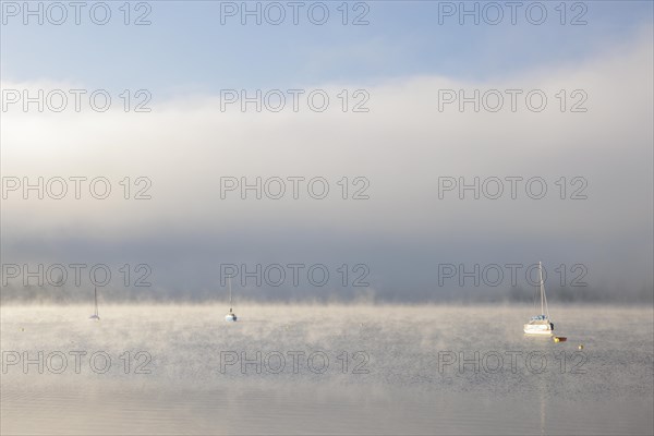 Fog over Lake Constance on an autumn morning with boats