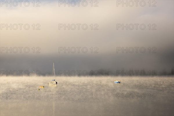 Fog over Lake Constance on an autumn morning with boats