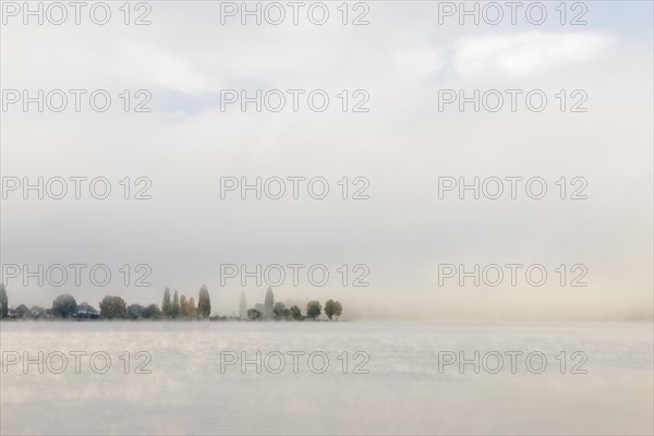 Fog over Lake Constance on an autumn morning with boats